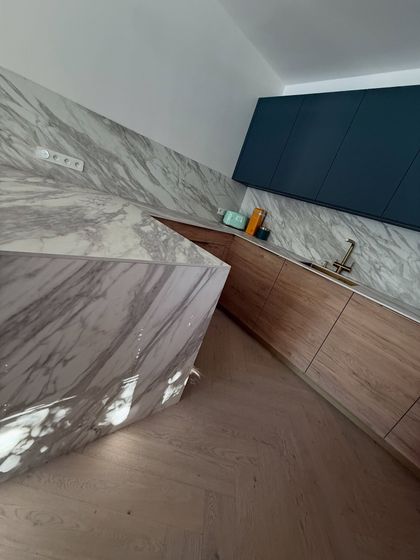 V této minimalistické kuchyni jsou zajímavé materiály jako například Fénix což je povrchová úprava která odolává otiskům prstů a je tak neustále dokonale matná.